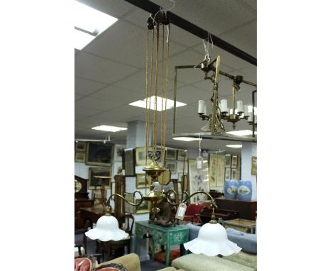 A brass rise/fall pendant ceiling lamp with scroll branches and opaque glass shade