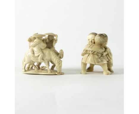 A Japanese carved ivory netsuke, Meiji period, depicting two young boys practising judo, signed Tomomasa and another netsuke 