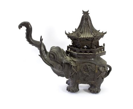 A Chinese bronze model of an elephant carrying a pagoda with trunk outstretched, ornately dressed, 46cm high/see illustration