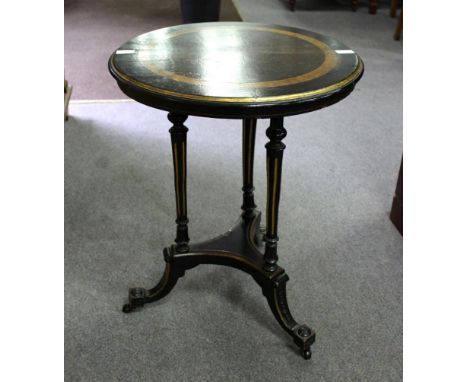 A late 19th Century ebonised and parcel gilt table, on tapered fluted supports and splay tripod base, 51cm diameter