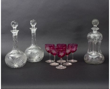 A suite of glassware engraved fruiting vines, comprising a pair of shaft and globe decanters, a waisted decanter and six pink