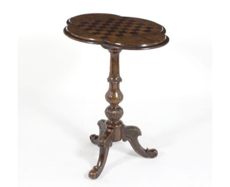 A Victorian walnut and inlaid games table, the quatrefoil top inlaid a chess board, on carved column and tripod support, 65.5