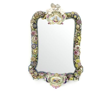 A 19th Century German porcelain framed mirror, the putto surmount above a cartouche painted a female portrait, the frame encr