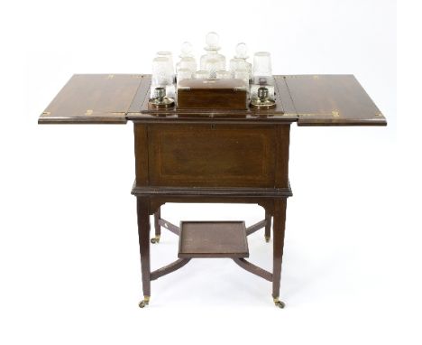 An early 20th Century cocktail cabinet, the mahogany case cross banded, fitted a sprung tray with glasses, a pair of plated c