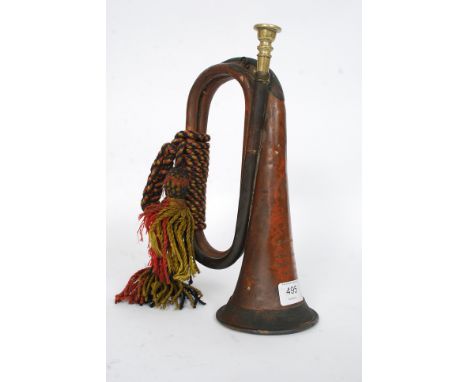 A military copper bugle complete with notation to the top having rope tassels and ties