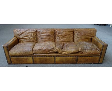 A 20th century brown leather upholstered brass studded four seat sofa, 258cm wide x 80cm high.