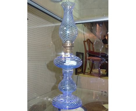 A 20th century glass oil lamp, with blue swirl decoration and shade. 