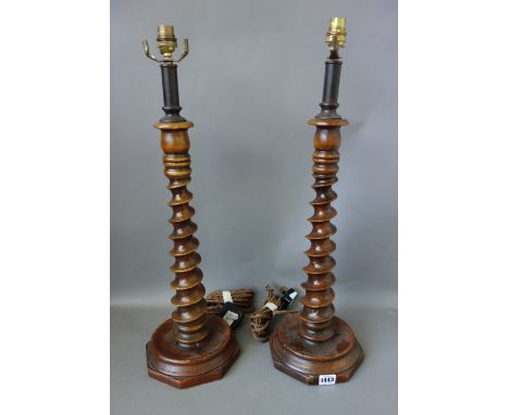 A pair of wooden spiral-twist table lamps, on octagonal bases, 48cm high, and a cylindrical copper and brass table lamp, with