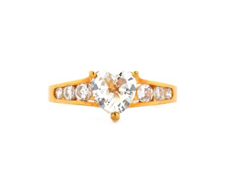 A gold and diamond set ring, claw set with the principal heart shaped diamond to the centre, between diamond set three stone 