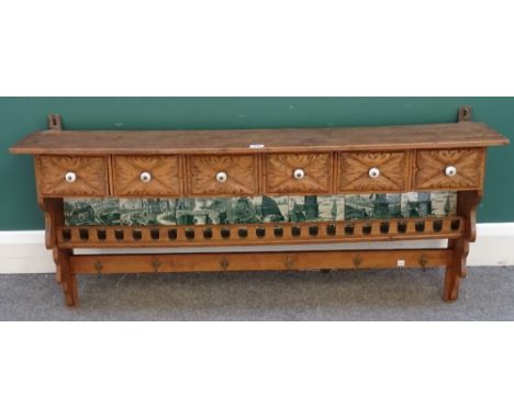 A late 19th century Continental pine and mixed wood hanging spice rack, five drawers above a green and white printed tile bac