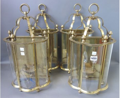 A set of four modern brass and glass wall lights, each with three shaped glass panels enclosing a two branch light fitment, s