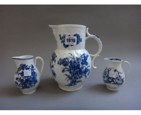 A Caughley porcelain mask jug, circa 1780, printed with `The Three Flowers' pattern,  19.5cm high, and two Caughley blue and 
