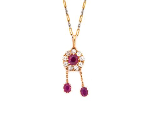 A gold, ruby and diamond set cluster pendant necklace, claw set with the principal cushion shaped ruby in a surround of nine 