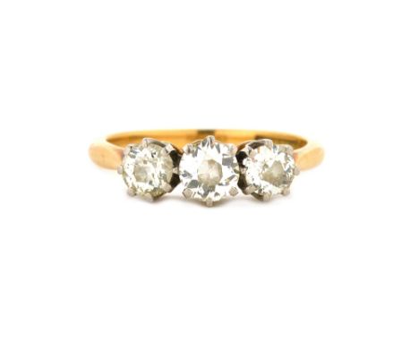 A gold and platinum, diamond set three stone ring, claw set with a row of cushion shaped diamonds, detailed 18 C & PLAT, ring