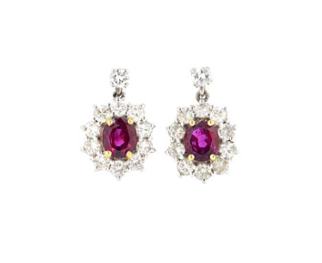 A pair of 18ct white gold, ruby and diamond set oval cluster earrings, each claw set with an oval cut ruby at the centre, in 