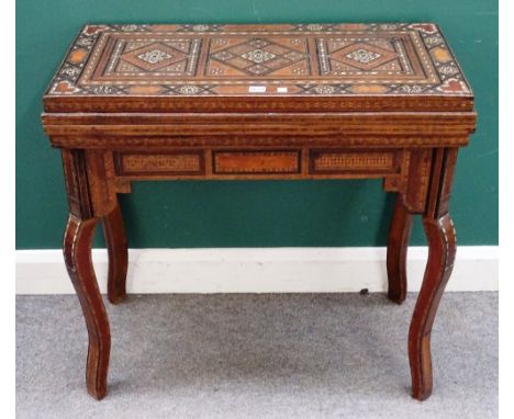 A late 19th century North African bone, mother of pearl and parquetry fold over card/games table, the stepped multi-function 