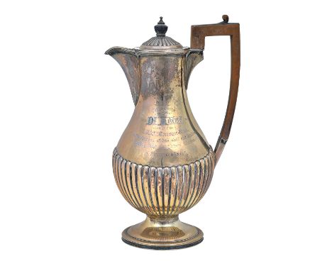 A late Victorian silver hot water jug, of baluster form, with partly fluted decoration and with wooden fittings to the handle