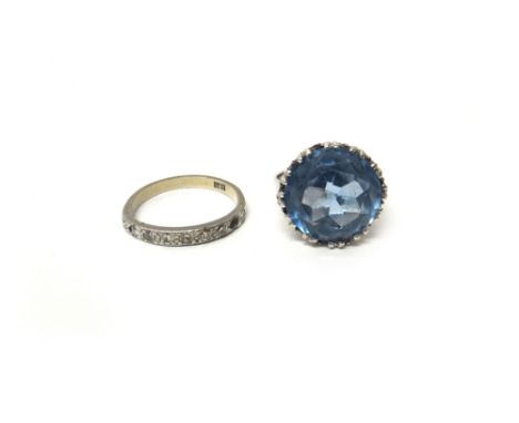 A white gold ring, claw set with a circular cut synthetic blue spinel, ring size L and a half and a white gold and diamond se