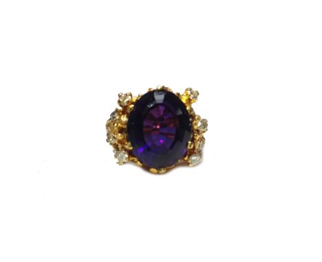 A gold, amethyst and diamond set ring, in an abstract design, claw set with the oval cut amethyst at the centre, between diam