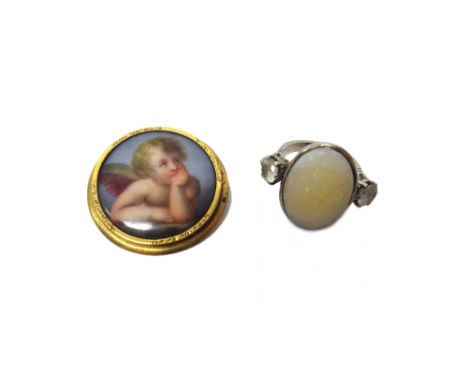 A gold mounted circular ceramic brooch, designed as the portrait of a pensive cherub, backed with mother of pearl and an opal