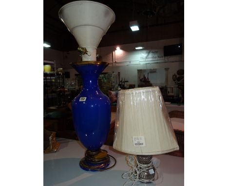 A large blue and gilt glass vase, later modified to a lamp, and a small oil lamp also later converted, (2).