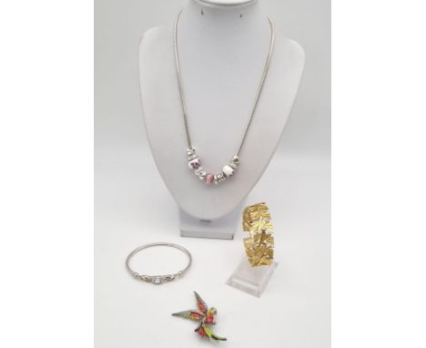 A Mixed Jewellery Lot: Necklace with charms, Enamel Parrot, Gilded bracelet and blue stone bangle. 
