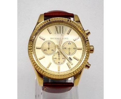 A Michael Kors Chronograph Gents Watch. Brown leather strap. Gilded case - 45mm. Champagne dial with three sub dials. Quartz 