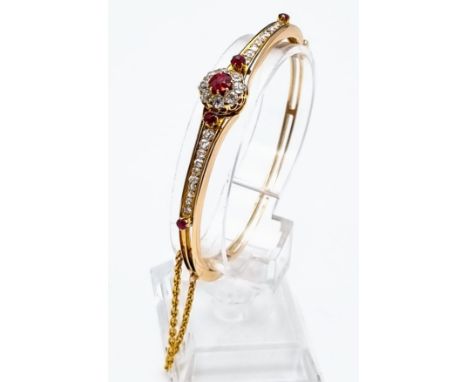 A Vintage 9K Yellow Gold Diamond and Ruby Bracelet. Central ruby surrounded by a halo of diamonds with diamond and ruby wings