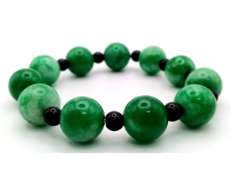 A Jade Beaded Expandable Bracelet with Garnet Spacers. 
