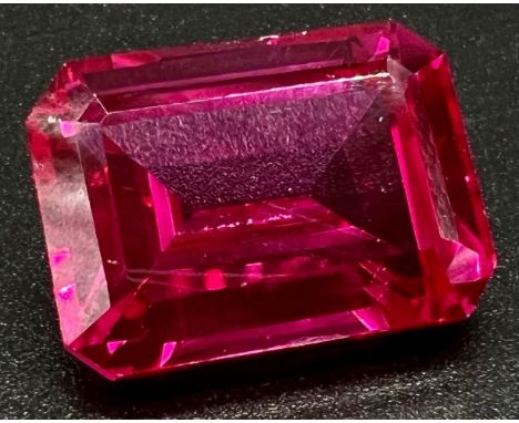 A wonderful, large (57,06 carats), pinkish red RUBY. Emerald cut, flawless, with uniform colour distribution and strong fluor