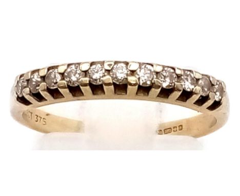 A 9 K yellow gold ring with a band of eleven diamonds (0.15 carats). Ring size: M, weight: 1.6 g. 