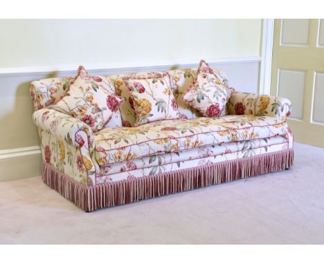 A Howard style three seater sofa late 20th century, in bold floral print upholstery, with fringed edging, 84in. (213.5cm.) lo