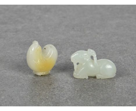 Two miniature Chinese carved jade pendants 20th century, comprising a recumbent white jade goat, (2.5cm. long; and a white ja