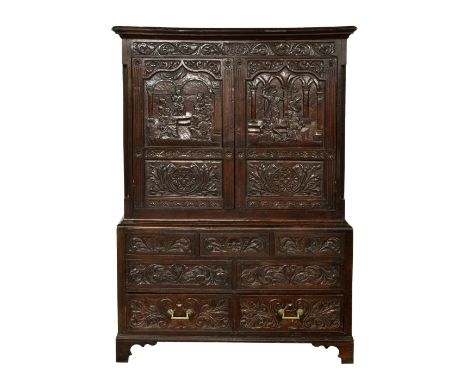 An early 18th century north European carved oak linen press the flared cornice over a foliate carved frieze with '1681' inscr