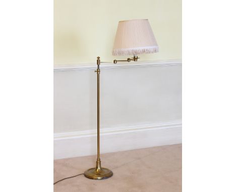 An adjustable brass reading lamp with dished circular base, hinged arm and pleated silk shade, 38¾in. to 51in. (98.5cm. to 12