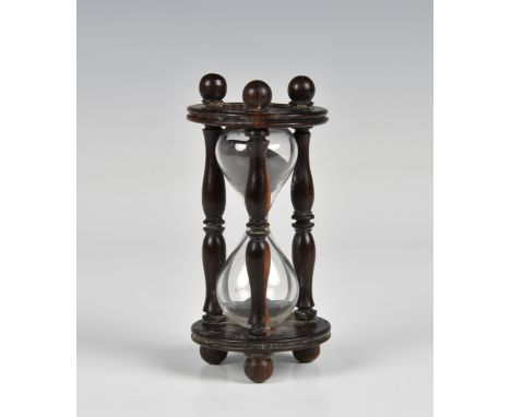 A 19th century treen hourglass of typical form, having turned bobbin supports, 4¼in. (10.8cm.) high.* Condition: Restoration 
