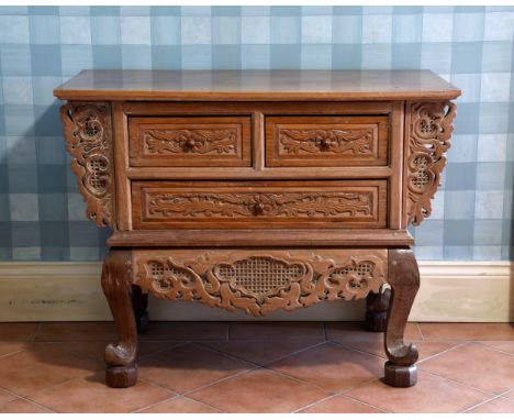 A Chinese carved teak three drawer chest 20th century, the rectangular top on pierced brackets over two short and one long dr