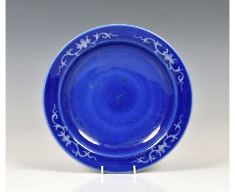 A Chinese reverse slip glazed blue &amp; white dish 19th century, the wide rim and underside decorated with floral &amp; foli