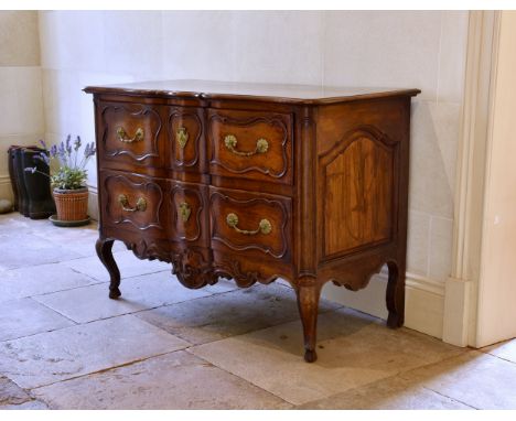 An 18th century French provincial walnut bombe two drawer commode the moulded top over two deep drawers and arched panelled s