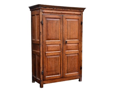 An 18th century six panel joined oak cupboard possibly Channel Islands, the (later) hollow moulded cornice over five panel si