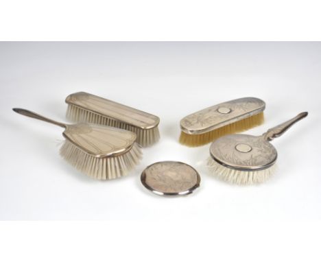 A three piece silver chinoiserie style dressing table set marked sterling, to include hairbrush, clothes brush and compact, h