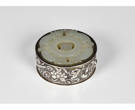 A Chinese silver seal paste or ink box with pale celadon jade prayer wheel probably 19th century, circular form with relief d