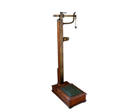 A set of Edwardian oak and brass jockey or surgery scales by W. &amp; T. Avery Ltd. impressed maker's mark to scale, with pla