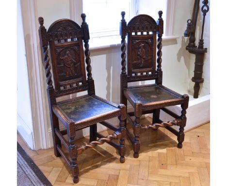 A pair of Victorian 17th century style carved oak and leather hall chairs the backs with a carved figural panel below an arch