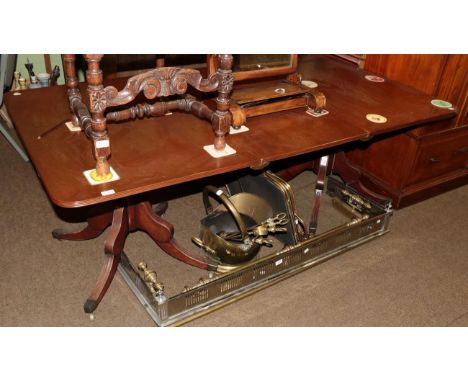 A George III style mahogany twin-pillar dining table, with one additional leaf, on turned supports with four sabre legs, bras