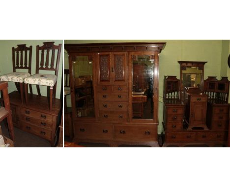 An Arts &amp; Crafts oak six piece bedroom suite, comprising a wardrobe, the cornice above two mirrored doors enclosing a cen