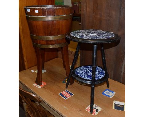 An oak and brass bound planter of staved construction, 69cm high; and an Arts and Crafts ebonised tile top two-tier circular 