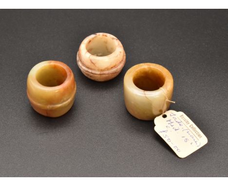 THREE CHINESE JADE ARCHERS THUMB RINGS, QING DYNASTY OR EARLIER清或更早 玉扳指一組 三隻The stones with russet inclusions, two carved wit