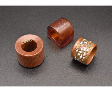 THREE CHINESE ARCHERS THUMB RINGS, QING DYNASTY, 19TH CENTURY清 玉扳指一組 三隻 十九世紀To include; a champlevé enamelled and gilt-metal 