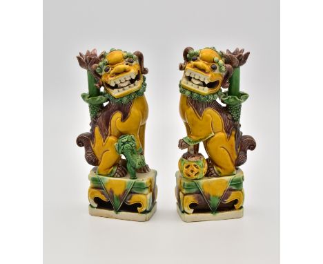 A PAIR OF CHINESE BISCUIT PORCELAIN LION DOG TAPERSTICK HOLDERS, QING DYNASTY, KANGXI PERIOD, 1662 – 1722清  康熙 1662 – 1722福獅擺